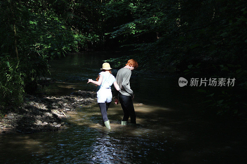 男孩和女孩在河边、林地里玩耍/涉水